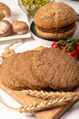 Round vegetarian patties or burgers made from grains, vital wheat gluten food, uncooked and grilled