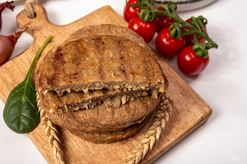 Round vegetarian patties or burgers made from grains, vital wheat gluten food, uncooked and grilled