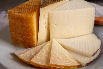 Assortment of Spanish hard cheeses, curado, manchego, goat cheese served for tasting, close up