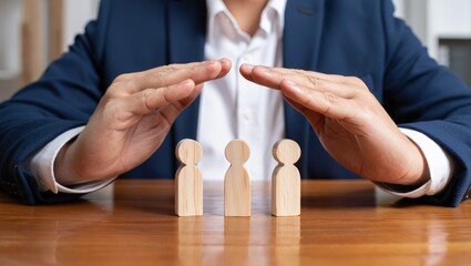 Businessman covering wooden figures of people. Employer commitment to protecting the human rights, labor rights, and providing support and insurance to employees within the community.