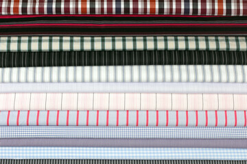 A collection of textured fabric swatches with plaid and stripe motifs in assorted hues, great for textile or interior design.