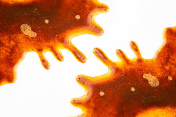 Abstract orange-brown stain splatter on white background, resembling spilled liquid or ink. Ideal for artistic projects, design elements, or creative backgrounds with a vibrant, organic texture.
