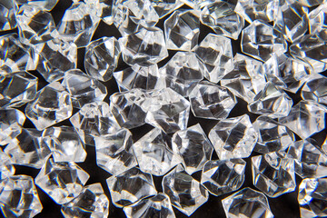 Sparkling clear crystals scattered on a dark surface, reflecting light beautifully, perfect for...