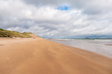 A beach with a cloudy sky in the background