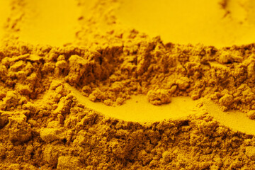Aromatic turmeric powder as background, closeup view