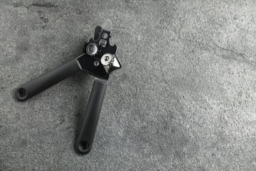 One can opener on grey table, top view. Space for text