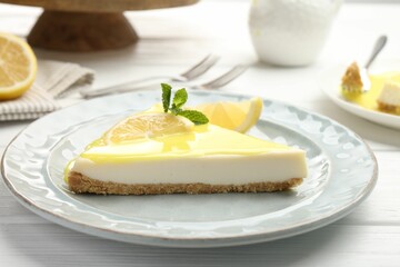 Piece of delicious cheesecake with lemon curd on white wooden table, closeup