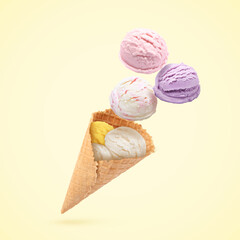 Ice cream scoops and waffle cone in air on beige background