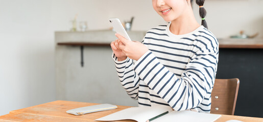 家でスマホを使いながら勉強する小学生,中学生の女の子,子供（困る,悩む）
