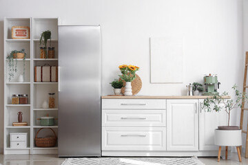 Interior of kitchen with modern fridge and white counter