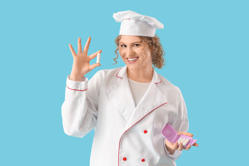 Female chef with tampons on blue background