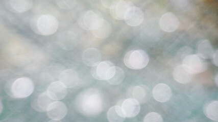 Fototapeta premium Abstract Bokeh background of raindrops mostly white on green background, plenty of space for copy or text with sparkling shades for a cheerful presentation