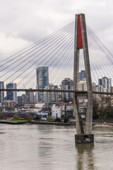 Naklejka premium Skytrain Bridge Spanning Fraser River with Urban Skyline in Vancouver, BC, Canada