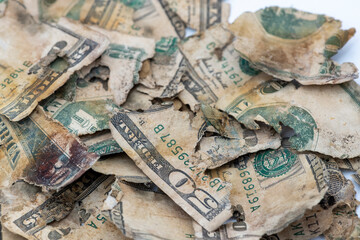 Weathered banknotes scattered on a surface, depicting wear and tear in aged currency