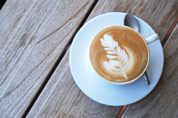 cup of coffee on wooden table, top down view