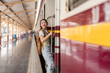 Obraz premium Joy and Travel Preparation. A young woman smiles while holding onto the train door.