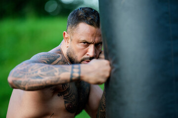 A fist of power man. A man fists clenched in anger. Close-up of face and hand of boxer ready for a fight. Strong arms and clenched fists. Danger look. Sport man exercise outdoor with boxing fists.