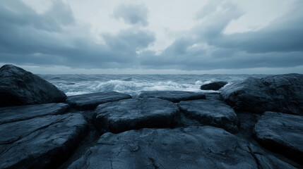 Obraz premium Dramatic Coastal Scene with Dark Rocks and Turbulent Waves under Gloomy Sky