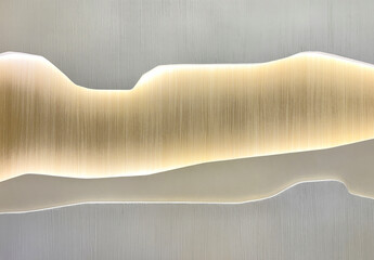 Close up of a white wall panel cut and carved in random mountain shape with back light shining on a...