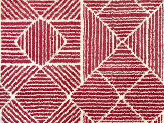 Close up red and white geometric patterns in triangular and diamond shape. Suitable for carpet, rug, and fabric. Seamless red geometric carpet seamless background texture.