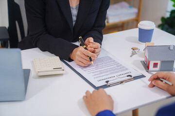 Businesswoman and real estate agents discussing documents signing a legal purchase of a house.