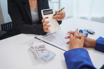 
Asian businessman in suit working at desk checking financial chart, handling car insurance claim, buying and selling car, analyzing car financing options, signing lease contract for car transaction.
