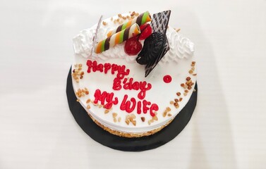 Birthday Cake with White Cream, Chocolate Toppings, and Happy Birthday Decoration