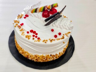 Birthday Cake with White Cream, Chocolate Toppings, and Happy Birthday Decoration