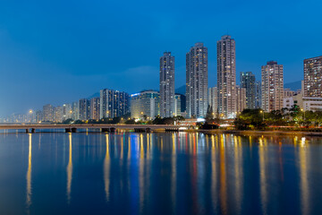 Obraz premium A night view of Sha Tin Wai and City One of Sha Tin District from the bank of The Shing Mun River. Hong Kong.