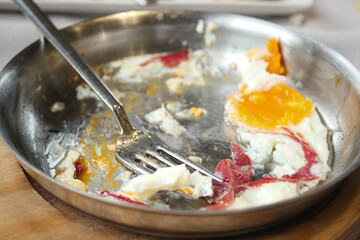 Plate with remnants of breakfast including eggs and meat