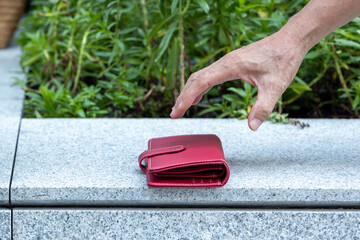 Hand picking up lost purse, concept image for lost and found