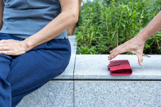 Old woman about to be pickpocketed, leaving her purse unattended and being stolen, concept Image of Urban crime, pick pocketing, petty criminal, caution beware of pickpocketeer