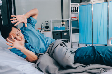 Lonely man silhouette sitting on the bed feeling depressed and stressed in the dark bedroom, Depression and anxiety disorder concept