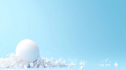 Soft white sphere nestled in a bed of delicate white flakes on a light blue background