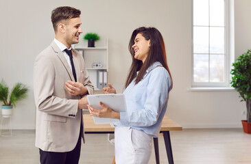 Fototapeta premium Office happy engaged diverse managers in formal clothed discussing business project, talking in office, manager training new employee, intern helping, corporate staff speaking, discussing smiling 