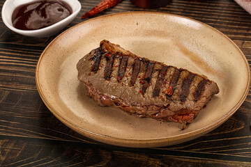 Grilled beef striploin steak with sauce