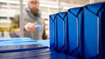 Close-up of many butter packs inside of a grocery fridge and a male consumer choosing one