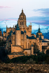 Fototapeta premium Segovia Alcazar and Cathedral against the snowy mountains.