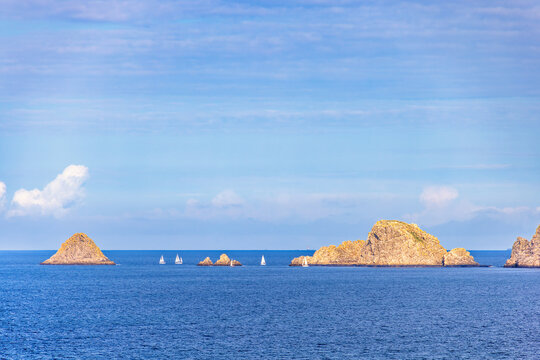 Seascape view with sailboats at sea rocks on the sea a sunny summer day