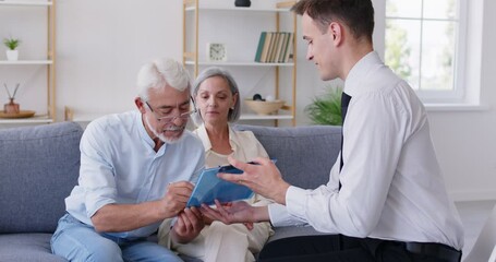 An elderly couple and a businessman sign a document, close-up. The senior people's financial advisor prepared the contract. Concept investment, health insurance, pension contract