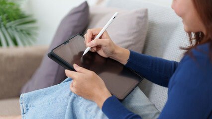 Digital Canvas: a woman artist is drawing and creating digital art using a modern tablet and...