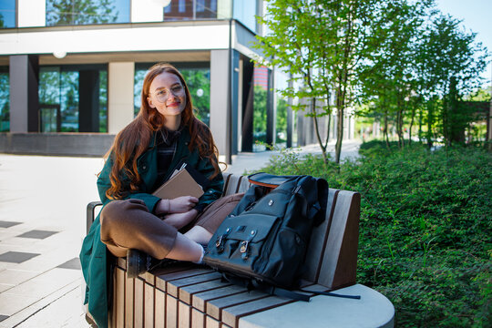 Student girl sitting with backpack near the university