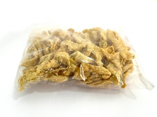 Fried wonton chips or Pangsit Goreng in a plastic bag isolated on white background. Crispy and savory Asian snack perfect as a side dish or topping for soups, noodles, and salads.