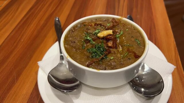 Close up shot of Hyderabadi Haleem garnished with dry fruits in Kolkata.