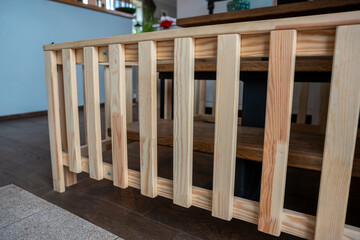 Light colored wooden slats on dark wooden floor, surrounded by modern furniture, a plant, and...