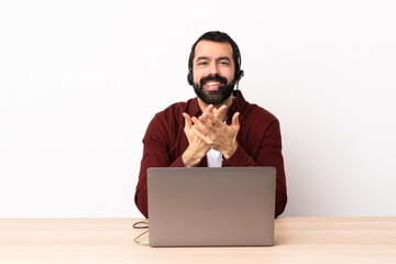 Telemarketer caucasian man working with a headset and with laptop laughing.