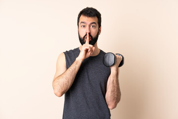 Caucasian sport man with beard making weightlifting over isolated background showing a sign of...