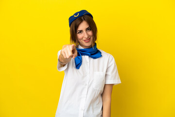 Airplane stewardess woman isolated on yellow background points finger at you with a confident expression