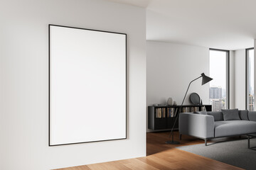 Large blank poster mockup on modern white wall in stylish interior with grey furniture and city view through windows, ideal for clean design presentations. 3D Rendering