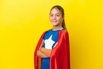 Super Hero little girl isolated on yellow background with arms crossed and looking forward © luismolinero